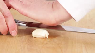 garlic-clove-being-crushed-with-a-knife-blade